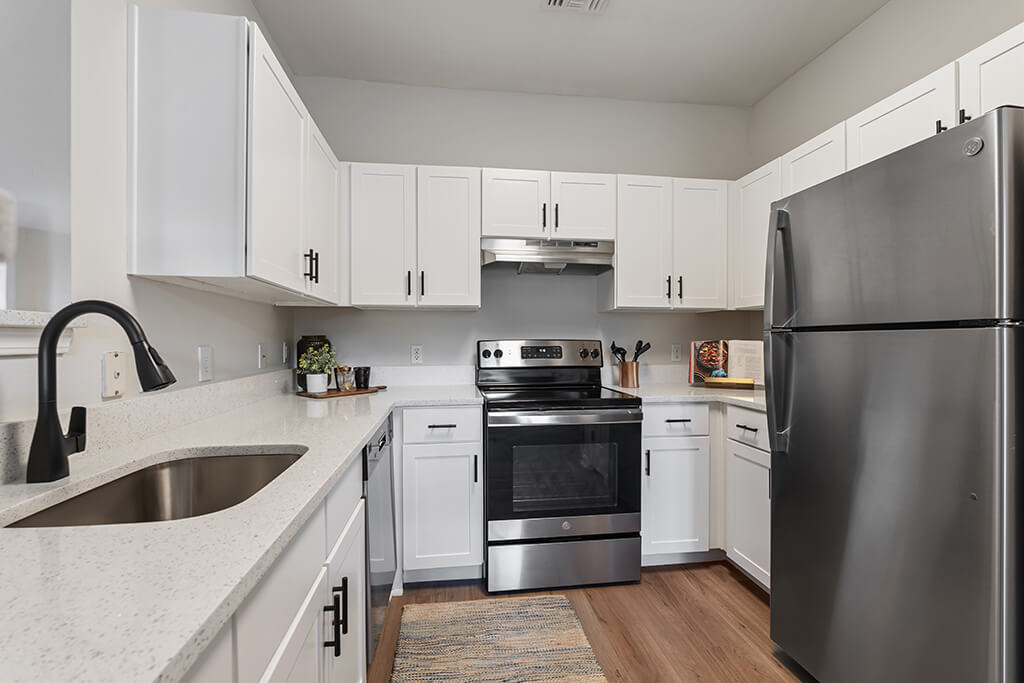 A warm kitchen overlooks the living room at the River Pointe at Den Rock Apartments in South Lawrence, Massachusetts.